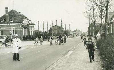 Klaar-overs helpen mensen veilig oversteken op een plek waar geen zebrapad is. Rijkevoort, 1975