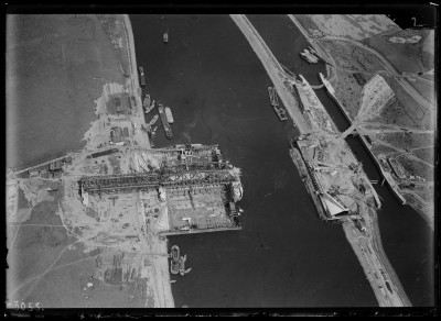 Luchtfoto van de bouw in de Maas van het Stuw en Sluizencomplex bij Grave en de aanleg van de Graafse brug als onderdeel van de aan te leggen autosnelweg tussen 's-Hertogenbosch en Nijmegen. 1919-1927 (Foto: Fototechnische Dienst Luchtvaartafdeeling, collectie Nederlands Instituut voor Militaire Historie, nr. 2011-0154)