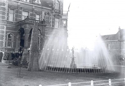 Vervolgens wordt de waterleiding officieel in gebruik gesteld door het openen van een waterkraan, waarna de fontein voor het gemeentehuis gaat spuiten. Oss 1935 (foto: Fotopersbureau Het Zuiden, collectie Stadsarchief Oss, nr. BHIC: BCO010730)