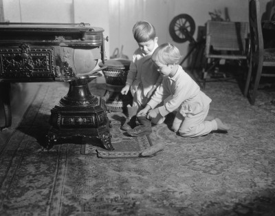 twee kindjes zetten hun schoen bij de kachel