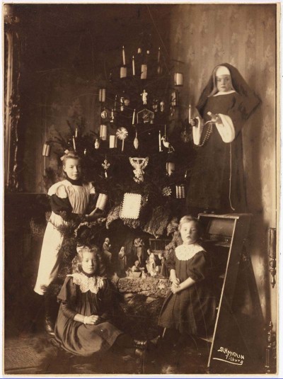 De kinderen Van der Zanden-Oosterbaan, verzameld rond de kerstboom. Er staat ook een kerststalletje en een meisje is verkleed als non. Tilburg, 1909