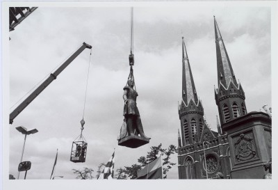 Het standbeeld van Willem II hangt in de takel. In 1993 werd het beeld tijdelijk verwijderd ten behoeve van een grondige schoonmaakbeurt. De Heuvelse kerk op de achtergrond.