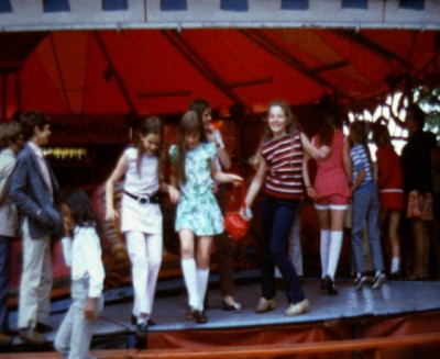 Dansen bij de botsauto's op de kermis, Nistelrode ca. 1970 (filmstill uit een familiefilm van de familie Van Oosterhout, heemkundekring Nistelvorst / collectie BHIC nr. OOS-06)