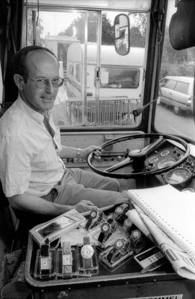 De meester en chauffeur van de kermisschool achter het stuur van de schoolbus