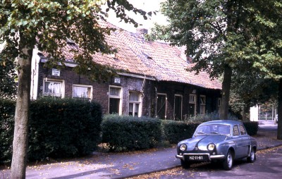 Straatbeeld met onbewoonbaar verklaarde woningen aan de Fortstraat in Vught; ervoor staat een auto van het merk Renault Dauphine (foto: Vera Delleman-de Kort, collectie BHIC nr. 1923-002194)