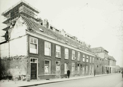 Afbraak woningen. Boven de woningen uit zijn gedeelten van de nieuwbouw van het Groot Ziekengasthuis te zien waarvoor de huizen moesten verdwijnen, 's-Hertogenbosch 1968 (foto: Fotopersbureau Het Zuiden, collectie Erfgoed 's-Hertogenbosch nr. 0021690)